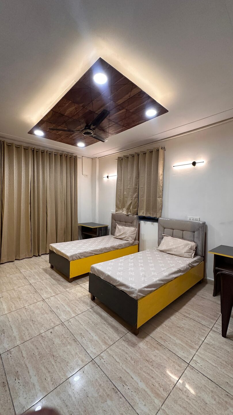 Spacious twin room with cushioned headboard beds and glossy tiled floor